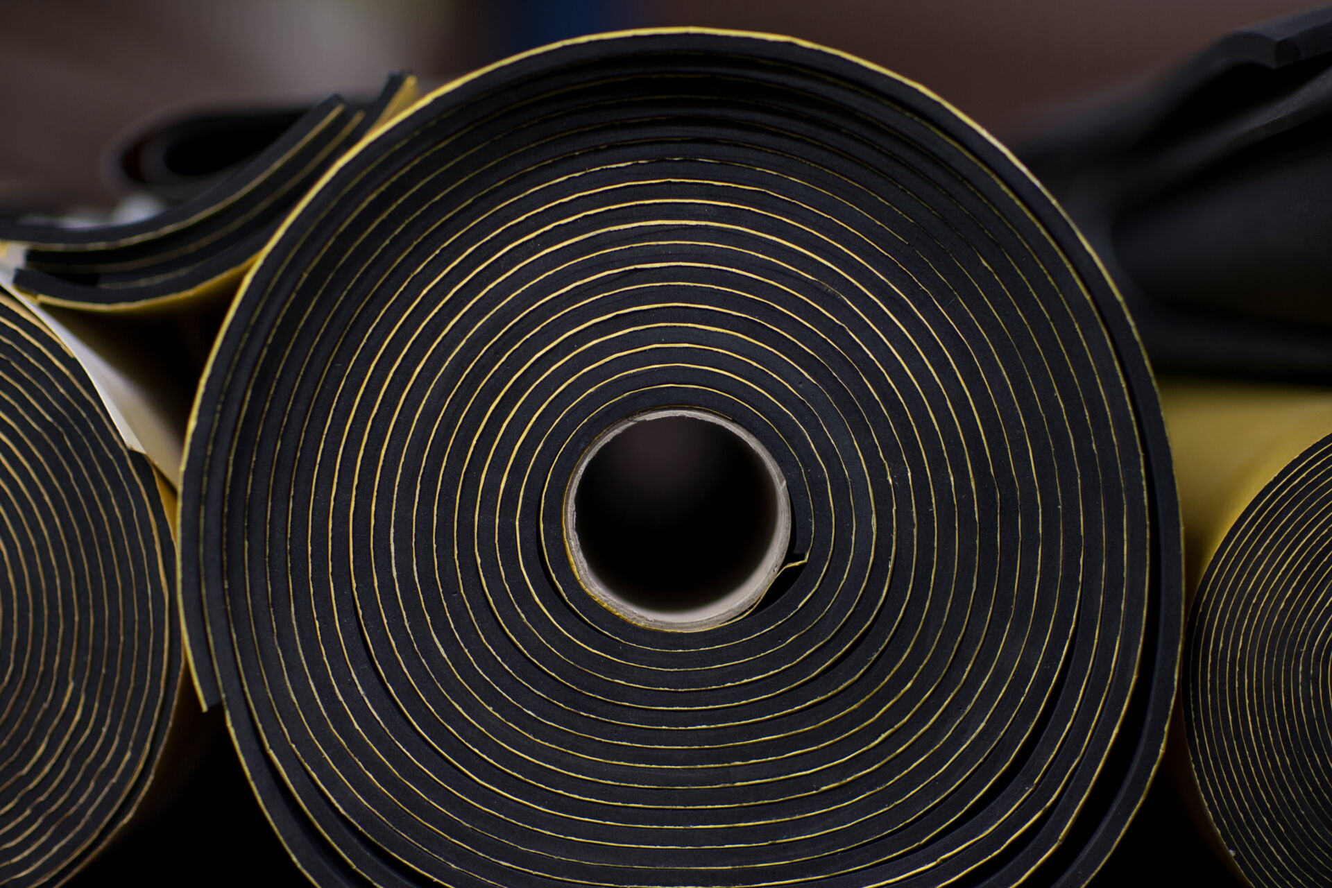 Aufgerolltes Dichtungsband in Schwarz mit gelben Akzenten; Dichtungstechnik von Ulrich Melzig GmbH.