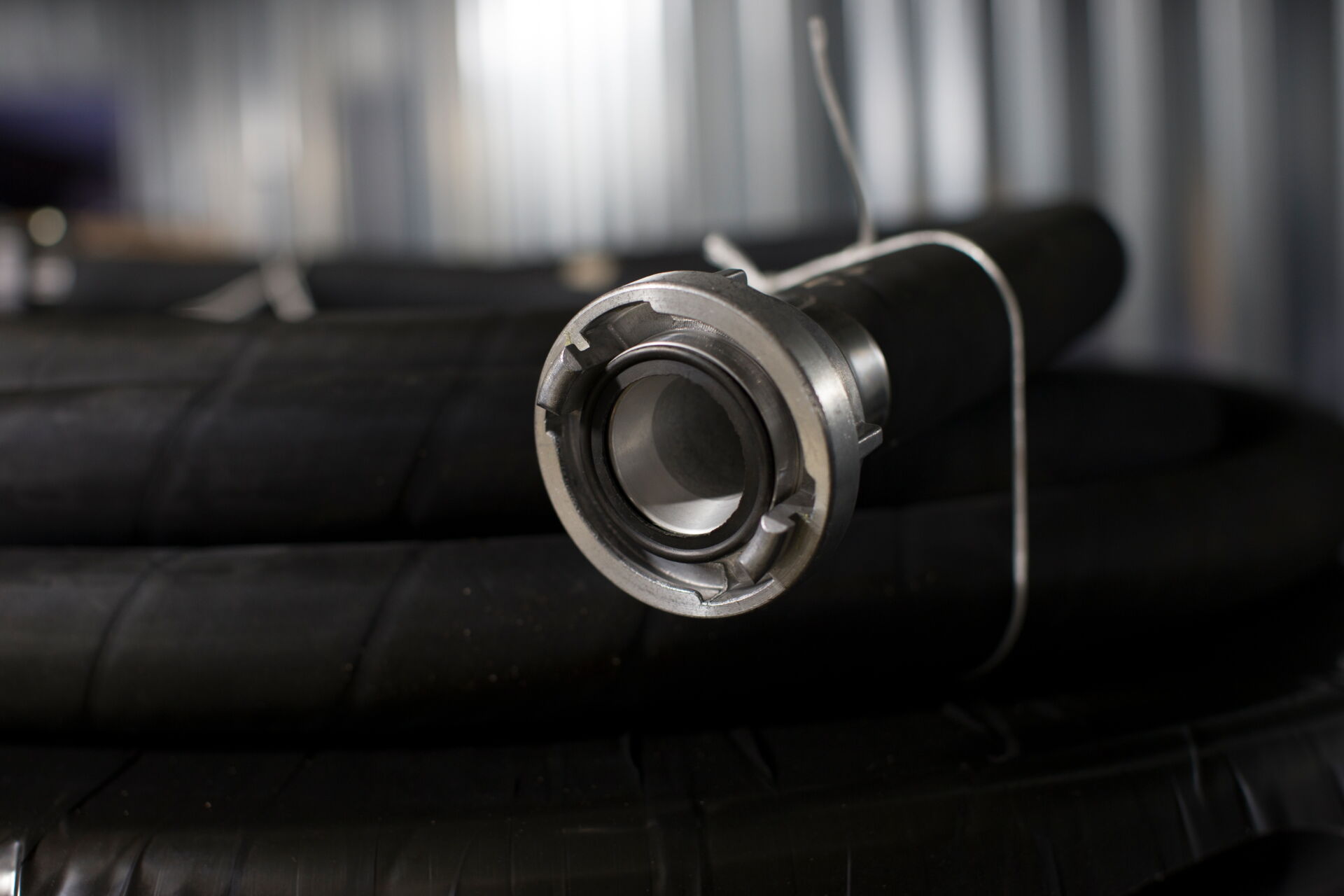 Nahaufnahme einer Schlauchdichtung aus Metall an einem schwarzen Schlauch; Dichtungstechnik von Ulrich Melzig GmbH in Dresden.