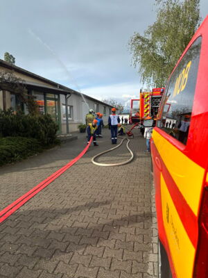 Jugendfeuerwehr bei einer Übung vor dem Gebäude von Sächsische Schlauch- und Dichtungstechnik Ulrich Melzig.