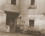 Historisches Schwarz-Weiß-Foto des Eingangs eines älteren Gebäudes; möglicherweise frühe Geschäftsräume von Melzig.