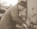 Historisches Schwarz-Weiß-Foto eines Mannes mit Hut bei der Arbeit; Ulrich Melzig in seinen frühen Jahren.